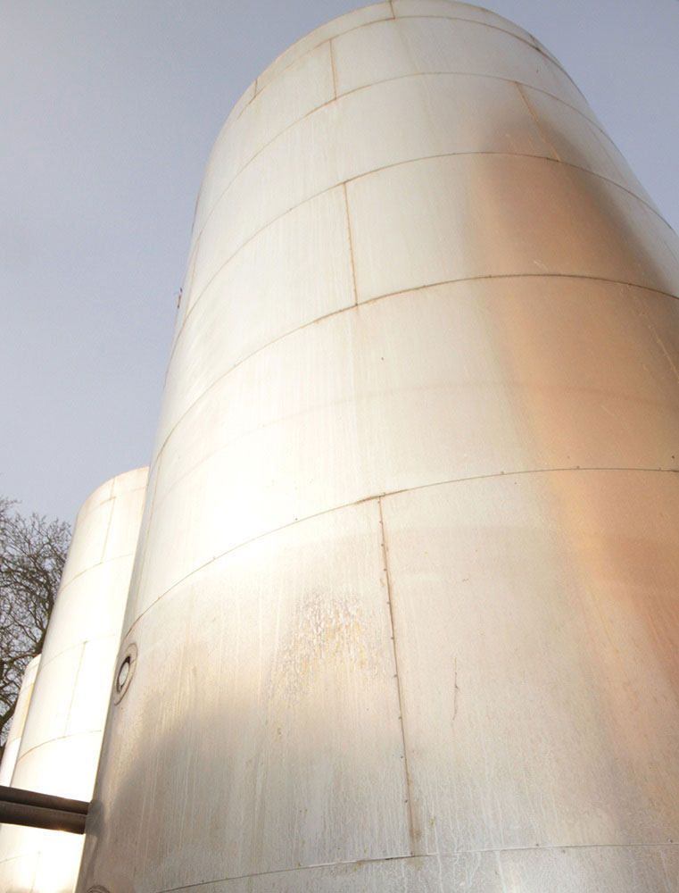 A large metal silo viewed from the ground.